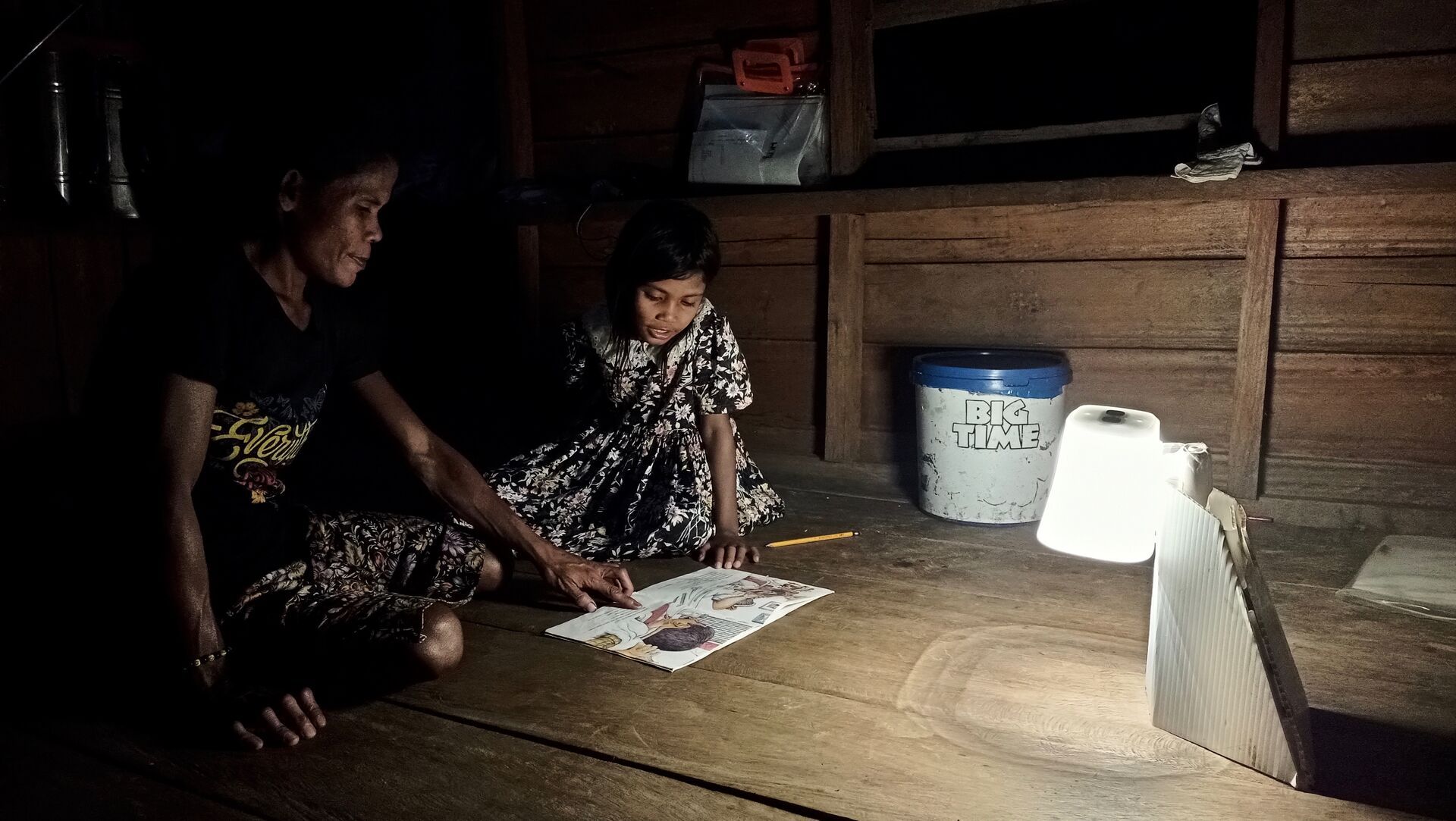 Children studying at night by the light of a Light for Hope solar lantern